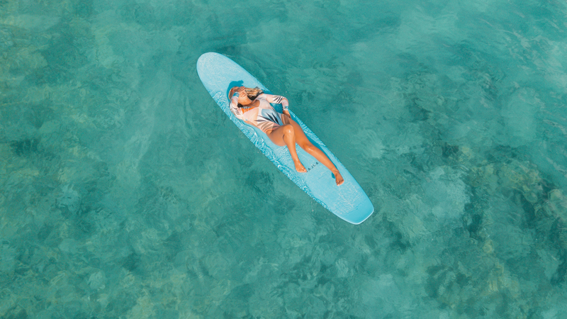 Photo by Jess Loiterton: a woman lying on the surfboard. Surfing as meditation 